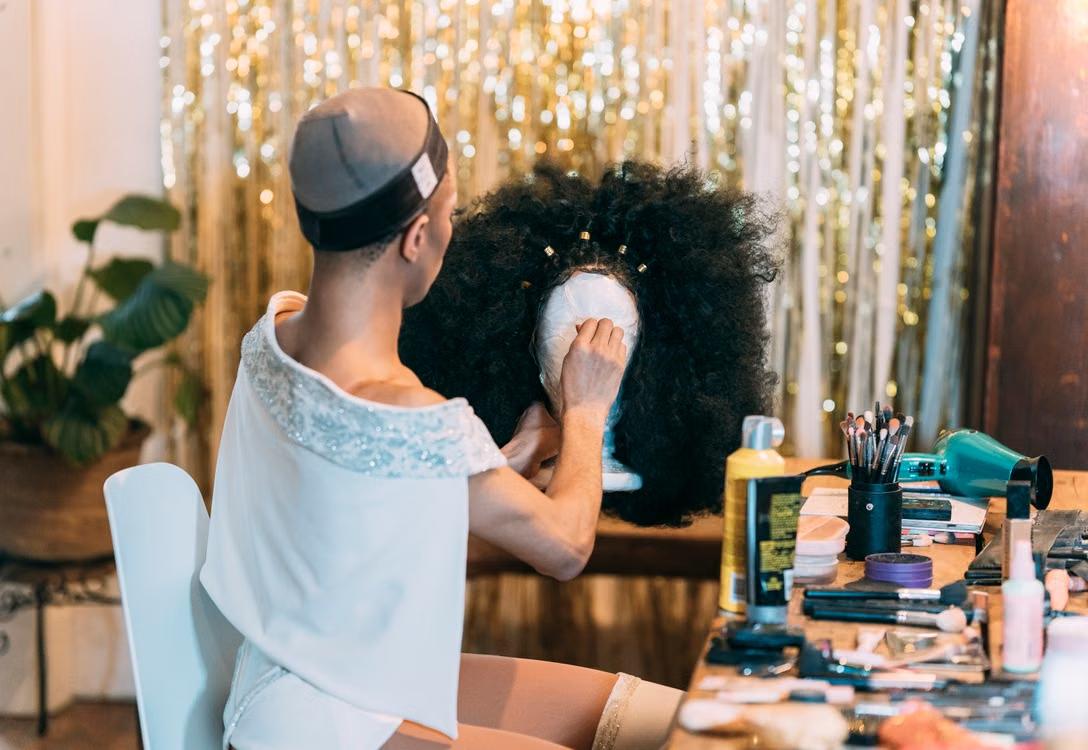 A person working with a black wig. 